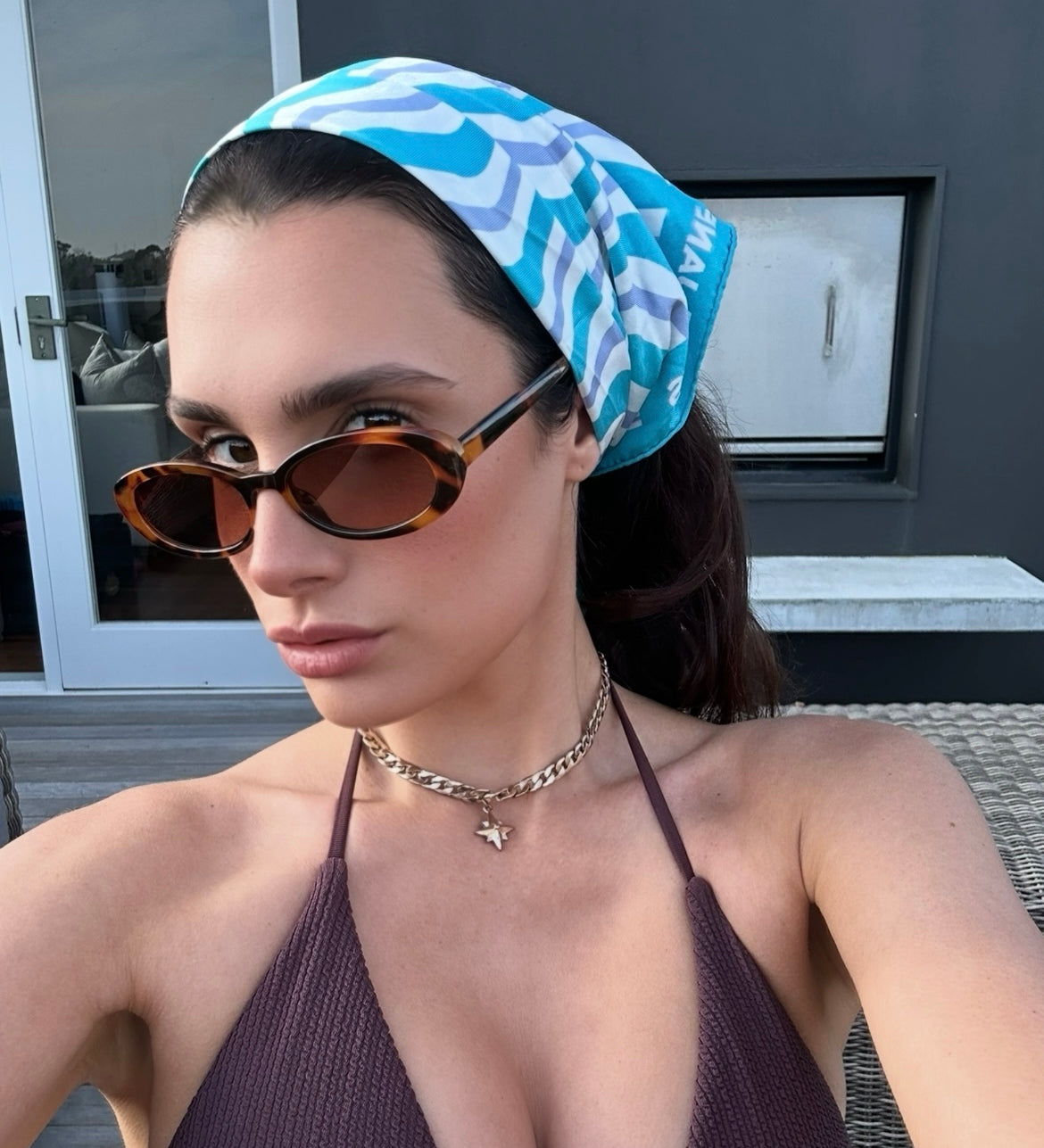 Allegra Jackson wearing sunglasses and a patterned headscarf outdoors